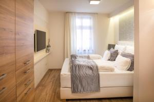um quarto com uma cama branca e uma janela em Főtér Rezidencia em Gyor