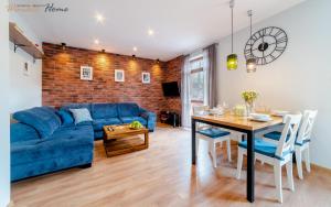 a living room with a blue couch and a table at Wonder Home - Apartamenty z prywatnymi saunami, w zielonej części Karpacza in Karpacz