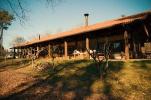 un gran edificio de madera con árboles delante de él en Albergue Bergando en Negreira