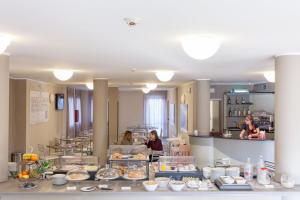 a bakery with people standing behind a counter at Green Class Hotel Candiolo in Candiolo
