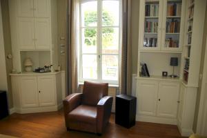 ein Wohnzimmer mit einem Stuhl und einem Fenster in der Unterkunft JOLIE PROPRIÉTÉ "VILLA CAMELIA" EN PLEIN COEUR DE L'EVENTAIL DE CABOURG in Cabourg