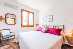 una camera con un letto e una sedia e una finestra di Fabulous Seaside Villa in Cala Sinzias a Castiadas