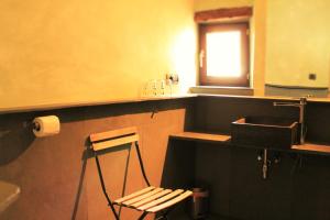 ein Badezimmer mit einem Waschbecken und einem Stuhl darin in der Unterkunft La Costa de Molló in Molló
