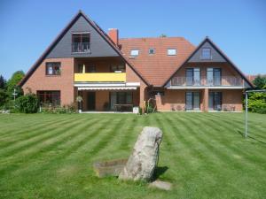una casa grande con una roca en el patio en Hotel Thünenhof, en Oyten