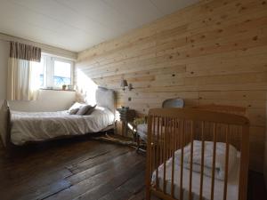 um quarto com paredes de madeira e um berço em Holiday home in Theux with indoor swimming pool and wellness em Theux