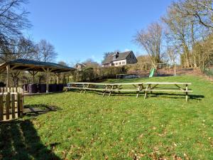 a park with two picnic tables in the grass at Modern Home with Bubble Bath and Sauna in Bra in Lierneux