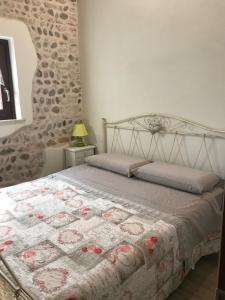 una camera da letto con un letto con una trapunta sopra di B&B La Piazzetta a Goito