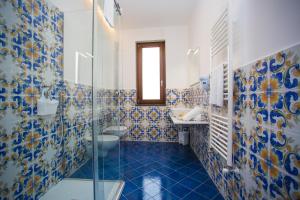 a bathroom with blue and white tiles on the wall at OASI FANTASIA in Agerola