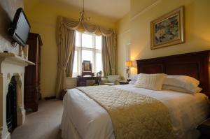 een slaapkamer met een groot bed en een raam bij Cotford Hotel in Great Malvern