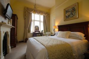 sypialnia z dużym łóżkiem i oknem w obiekcie Cotford Hotel w mieście Great Malvern