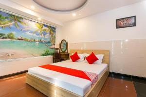 a bedroom with a bed with red pillows and a painting at Song Xanh Hotel near SECC - FV in Ho Chi Minh City