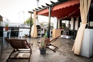 an outdoor patio with two chairs and a grill at La abuela Pepa Fácil Aparcamiento in Mérida