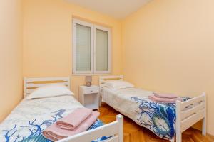 2 camas individuais num quarto com uma janela em Finnella em Dubrovnik