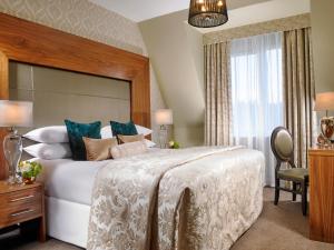Un dormitorio con una gran cama blanca y una ventana en Carrigaline Court Hotel & Leisure Centre en Cork