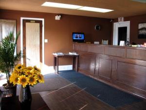 a waiting room with a cash register and flowers in a room at Stardust Motel in Shaunavon