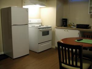 a kitchen with a white refrigerator and a table at Stardust Motel in Shaunavon