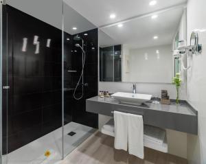 a bathroom with a shower, sink, and tub at H10 Gran Tinerfe - Adults Only in Adeje