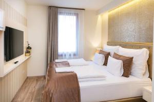a bedroom with a large white bed with a window at Főtér Rezidencia 2 in Győr