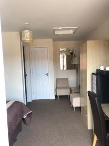 a bedroom with a bed and a desk and a chair at Newent Golf Club and Lodges in Newent