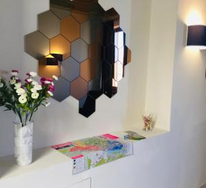 a room with a vase of flowers and a mirror at 1suite firenze in Florence