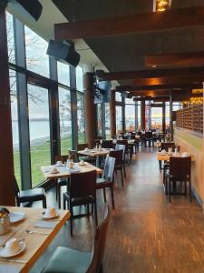 - une salle à manger avec des tables, des chaises et des fenêtres dans l'établissement Hotel Hafenresidenz Stralsund, à Stralsund