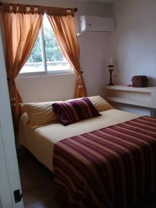 1 dormitorio con 1 cama grande y ventana en Alto Belgrano en San Salvador de Jujuy