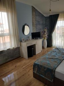 a bedroom with a bed and a tv and a mirror at Vromos Guest Rooms in Chernomorets