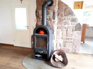 a wood stove with a pumpkin in a room at Ferienwohnung Farrenkopf in Hambrunn