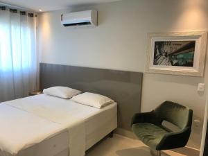 a small bedroom with a bed and a chair at Beach Class in Recife