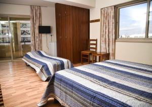 ein Hotelzimmer mit 2 Betten und einem Fenster in der Unterkunft Elysso Hotel in Larnaka