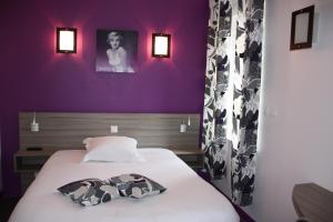 Bett in einem Zimmer mit lila Wänden in der Unterkunft Hôtel L'Argonn' Auberge in Apremont