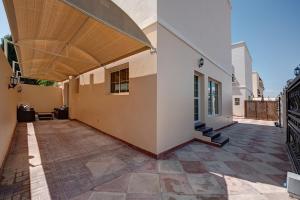 une terrasse intérieure d'une maison avec un auvent en bois dans l'établissement J5 Four Bedroom Villa Holiday home in Mirdif, à Dubaï