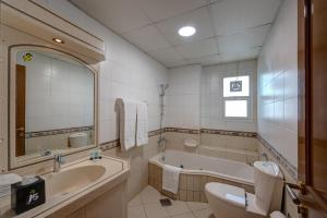 ドバイにあるJ5 Four Bedroom Villa Holiday home in Mirdifのバスルーム(バスタブ、トイレ、シンク付) +1枚の写真
