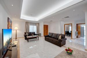sala de estar con 2 sofás y TV en J5 Four Bedroom Villa Holiday home in Mirdif en Dubái