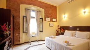 Un dormitorio con una cama grande y una ventana en Solar do Carmo Suites & Apartments, en Salvador