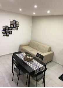 un salon avec un canapé, une table et des chaises dans l'établissement Nel Cuore di Napoli, à Naples