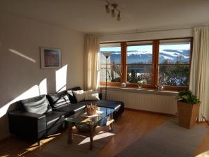 een woonkamer met een bank en een tafel bij Ferienwohnung Elgert in Scheidegg