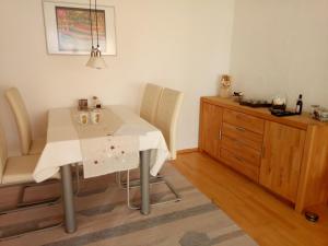 a dining room table with chairs and a dresser at Ferienwohnung Elgert in Scheidegg