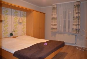 um quarto com uma cama com uma flor rosa em Ferienwohnung 10 im Haus Hühnergott em Ostseebad Sellin