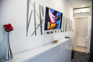 a white wall with a picture of a tv on it at Hotel Cool Zagreb Airport in Velika Gorica