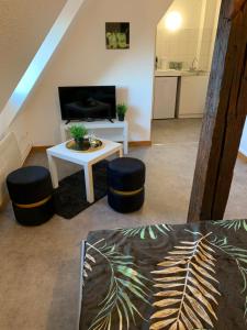 een woonkamer met een tafel en 2 krukken bij Studio à Ribeauvillé in Ribeauvillé