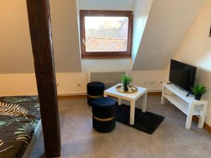 Habitación con cama, mesa y TV. en Studio à Ribeauvillé en Ribeauvillé