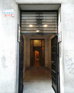 una entrada a un edificio con una puerta abierta en Hostal Gaudí, en Madrid
