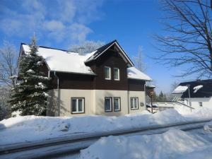 a house with snow on the side of a road at Pension Oberhof 810 M in Oberhof