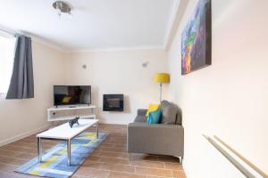 ein Wohnzimmer mit einem Sofa und einem Tisch in der Unterkunft Guest Homes - Hanover Apartment in Swansea