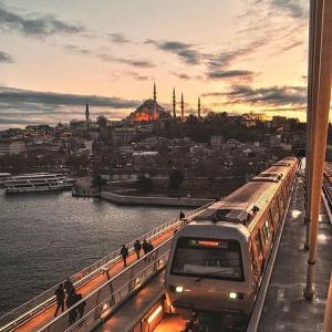 a train on a bridge with a view of a city at Golden Gate Hotel Old City in Istanbul