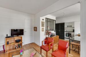 uma sala de estar com uma mesa e duas cadeiras vermelhas em Design apartment with terrace by Weekome em Paris