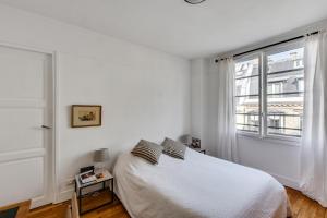 um quarto branco com uma cama e uma janela em Design apartment with terrace by Weekome em Paris