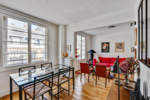 uma sala de estar com uma mesa de vidro e um sofá vermelho em Design apartment with terrace by Weekome em Paris