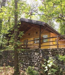 eine Hütte im Wald mit einer Steinmauer in der Unterkunft CHALET ETNA MILO in Milo